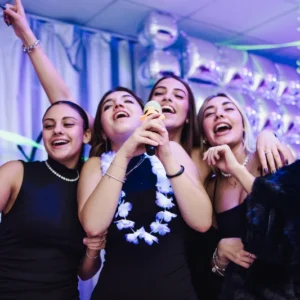 Ragazzi cantano durante un momento karaoke in AREA FLUO, la location fluo ideale per feste private a Roma.