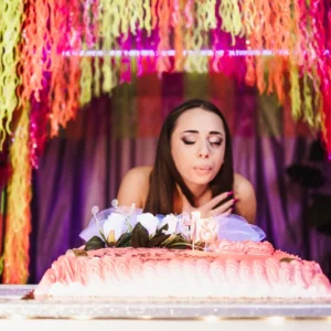 Ragazza che spegne le candeline durante una festa di compleanno in AREA FLUO, location unica a Roma.